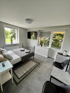 a bedroom with a bed and a couch and windows at Apartamenty Ostoja in Łeba