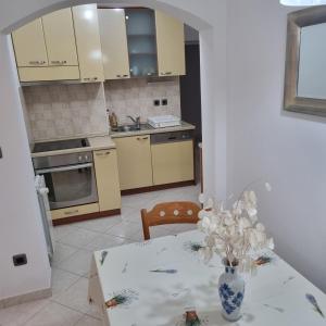 a kitchen with a table with a vase of flowers at Villa Mila in Bol