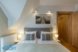 1 dormitorio con 1 cama con 2 almohadas en Apartamenty BlueSky - Pusta 8 - blisko szlaków i wyciągów en Karpacz