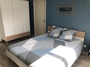 a bedroom with a bed with a hello sign on the wall at L'escapade in Saint-Léger-les-Mélèzes