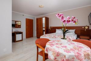 Un dormitorio con una mesa con un jarrón de flores. en Willa Rawia, en Rewal