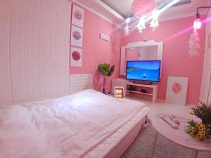 a pink bedroom with a bed and a tv at Spring Light in Seoul
