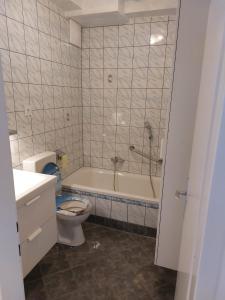 a bathroom with a tub and a toilet and a sink at Seewohnung Zentral in Millstatt