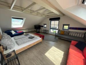 ein großes Wohnzimmer mit einem Bett und einem Sofa in der Unterkunft Kunst und Bergbauflair an der Ruhr - inklusive Netflix & Prime in Bochum