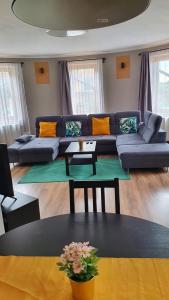 a living room with a blue couch and a table at Pannonia Apartman in Esztergom