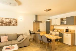 een woonkamer en een keuken met een bank en een tafel bij Apartmaji Jezerka in Bled