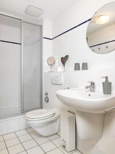 a white bathroom with a toilet and a sink at FIP Park Sonnennest in Gollwitz