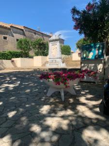 a statue with pink flowers in a courtyard at Chez Mimy in Valros