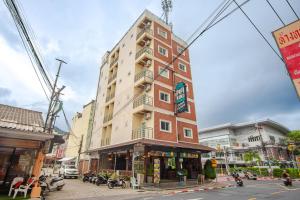 a tall building on the corner of a street at Pipikuku Hotel & Restaurant in Patong Beach