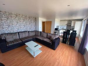 a living room with a couch and a brick wall at Britannia Apartments in Edinburgh
