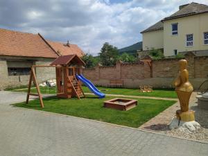 um quintal com um parque infantil com um escorrega e uma estrutura de jogos em U svaté Rozálie em Horní Vestonice