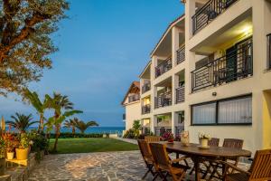 アリケスにあるSea View Hotelの建物の前にパティオ(テーブル、椅子付)