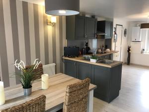 a kitchen with a wooden table and a counter top at maison 4 personnes tout confort alentours boulogne sur mer in Samer