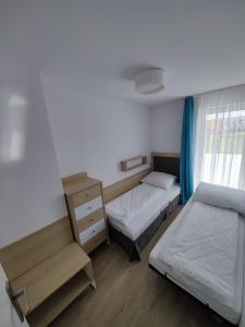 グジボボにあるDomki Bałtycka 14aの小さなベッドルーム(ベッド2台、ドレッサー付)