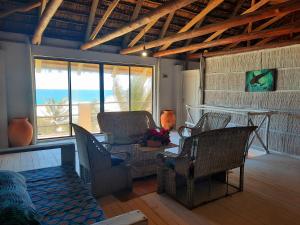 un soggiorno con sedie e tavolo con vista sull'oceano di Casa Malcampo a Praia do Tofo