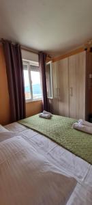 sypialnia z 2 łóżkami i oknem w obiekcie Apartman Norma free parking w Rabacu