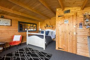 een slaapkamer met een bed in een houten hut bij Secret & Secluded Sedlescombe in Battle