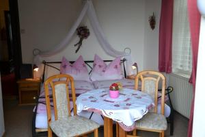 a bedroom with a table and a bed with pink pillows at Sand-Hof 