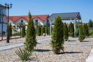 una fila de árboles en un patio con casas en Domki Scandinavia en Rowy