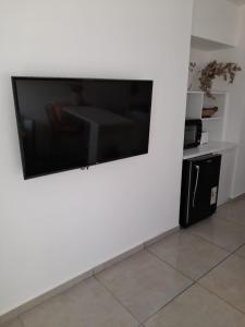 TV de pantalla plana colgada en una pared blanca en Departamento moderno y luminoso, en planta baja, con patio y excelente ubicación en Rafaela