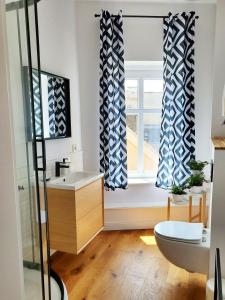 baño con lavabo y ventana en Centrum Grand Apartament, en Świdnica