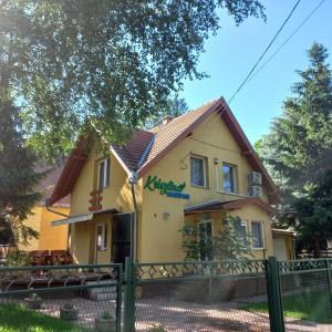 a yellow house with a fence in front of it at Krisztina Apartman 1- Szigethalom in Szigethalom