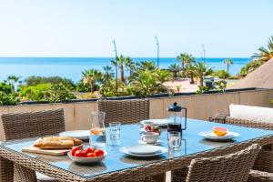 a blue table with food on a balcony with the ocean at Beach apartment with terrace and private parking in Radazul