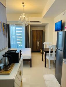 a kitchen and living room with a refrigerator and a table at Davao Boutique Condos - Inspiria Abreeza in Davao City