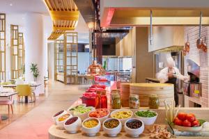 una cocina con muchos tazones de comida en una barra en dusitD2 Salwa Doha en Doha