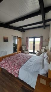 ein großes Bett in einem Zimmer mit Fenster in der Unterkunft Ballykeel Farm, Mourne Mountains in Ballymartin