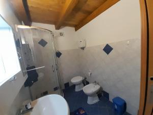 a bathroom with two toilets and a shower and a sink at Appartamenti Cryfani in Pizzo