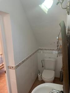 a white bathroom with a toilet and a sink at retreat studio in Santa Eularia des Riu