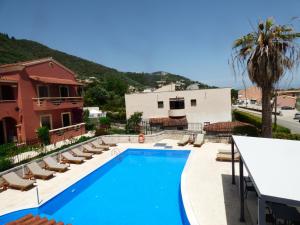 a swimming pool with lounge chairs and a building at Villa Sofia in Ýpsos