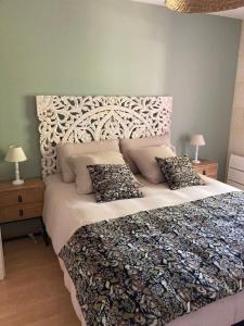 a bedroom with a large bed with a large white headboard at Wine Hôte Chambre d'hôtes in Le Pian-Médoc
