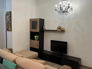 sala de estar con TV y lámpara de araña en Paradiso del Relax, en Alessandria