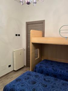 1 dormitorio con litera y colcha azul en Paradiso del Relax, en Alessandria