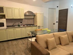 cocina con sofá y mesa de cristal en Paradiso del Relax, en Alessandria