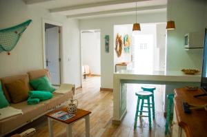 a living room with a couch and a kitchen at Turquesa Beach&Pool Apartaments in Playa Honda