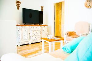 una sala de estar con TV de pantalla plana en un armario blanco en Turquesa Beach&Pool Apartaments, en Playa Honda