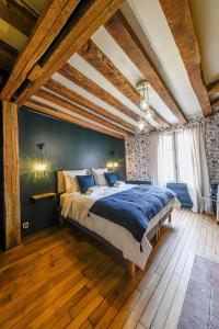 um quarto com uma cama grande num quarto com pisos em madeira em Maison Simart em Troyes