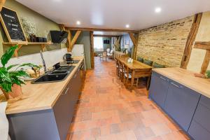 een keuken en eetkamer met een bakstenen muur bij Maison Simart in Troyes