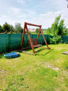 a swing set sitting in the grass in a yard at Domek holenderski Sosnowa in Wilkasy