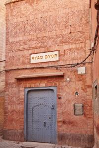 ein Backsteingebäude mit einer blauen Tür und einem Straßenschild in der Unterkunft Ryad Dyor in Marrakesch