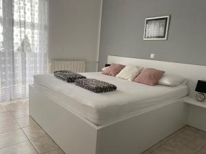 a white bed with two pillows on it in a bedroom at Emanuela 1 in Novalja
