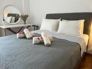 a bedroom with a bed with pillows and a mirror at Theo Suites in Kavala