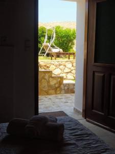 an open door to a patio with a chair outside at Kalypso apartment in Halki