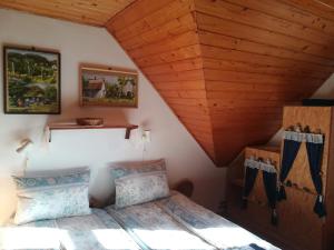 um quarto com uma cama e um tecto de madeira em Kishalász Vendégház-Lovas em Lovas
