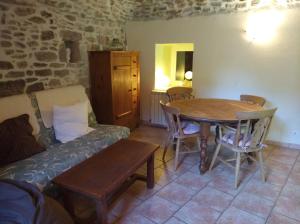 ein Wohnzimmer mit Sofa und Tisch in der Unterkunft Les Terrasses, gîtes en Cévennes in Saint-Jean-de-Valériscle