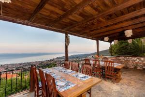 a dining room with a table and chairs on a balcony at Papazlıkhan Hotel in Altınoluk