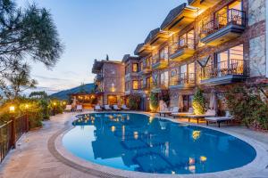 un hôtel avec une piscine en face d'un bâtiment dans l'établissement Papazlıkhan Hotel, à Altınoluk